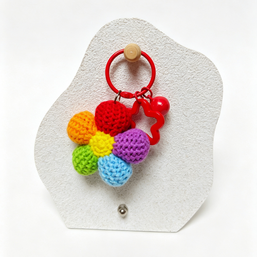 Colorful crocheted flower keychain on a white background